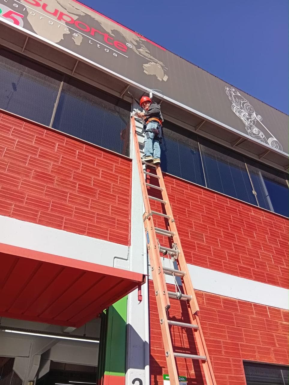 Técnico da Aletel trabalhando na fachada de uma empresa
