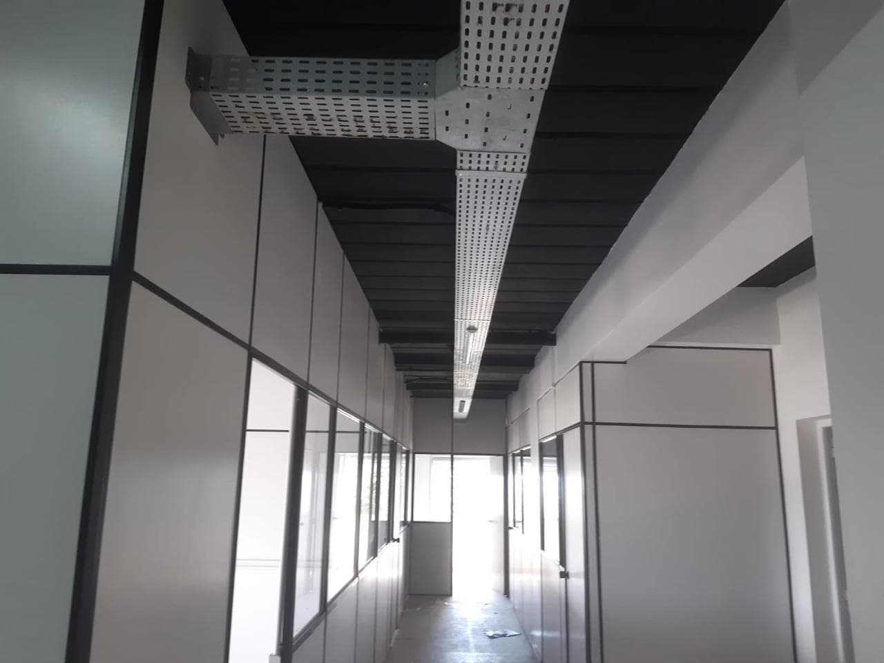 Eletrocalhas e iluminação instaladas em corredor corporativo