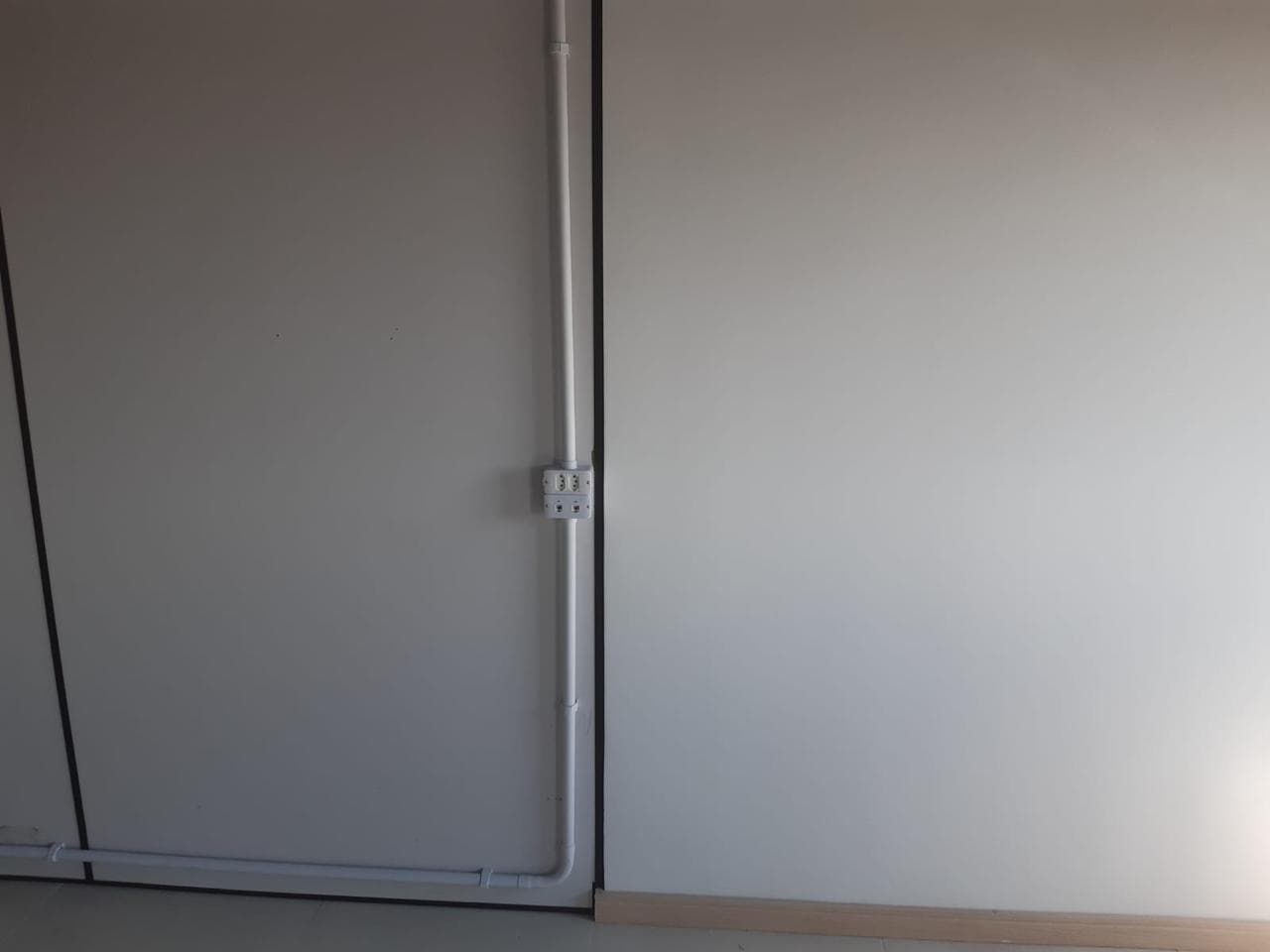 Tomadas e eletrodutos instalados sobre divisória de escritório