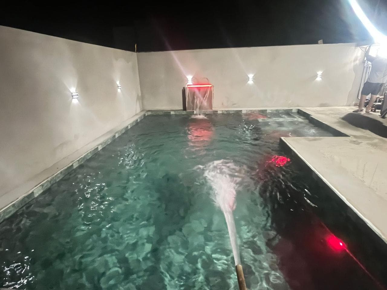 Piscina residencial com iluminação colorida e jatos de água
