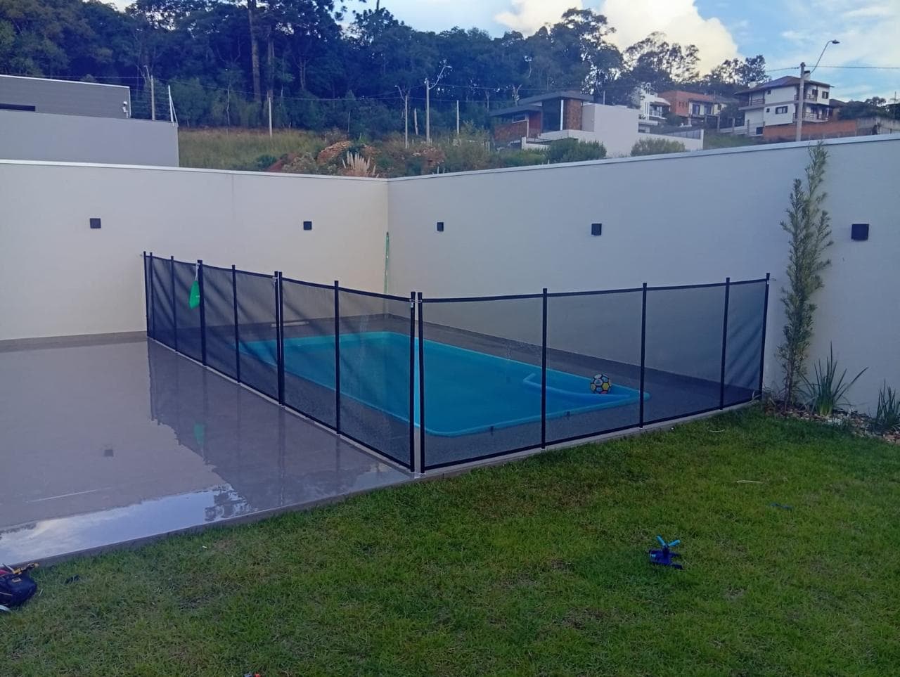 Vista lateral de piscina com cerca de proteção instalada
