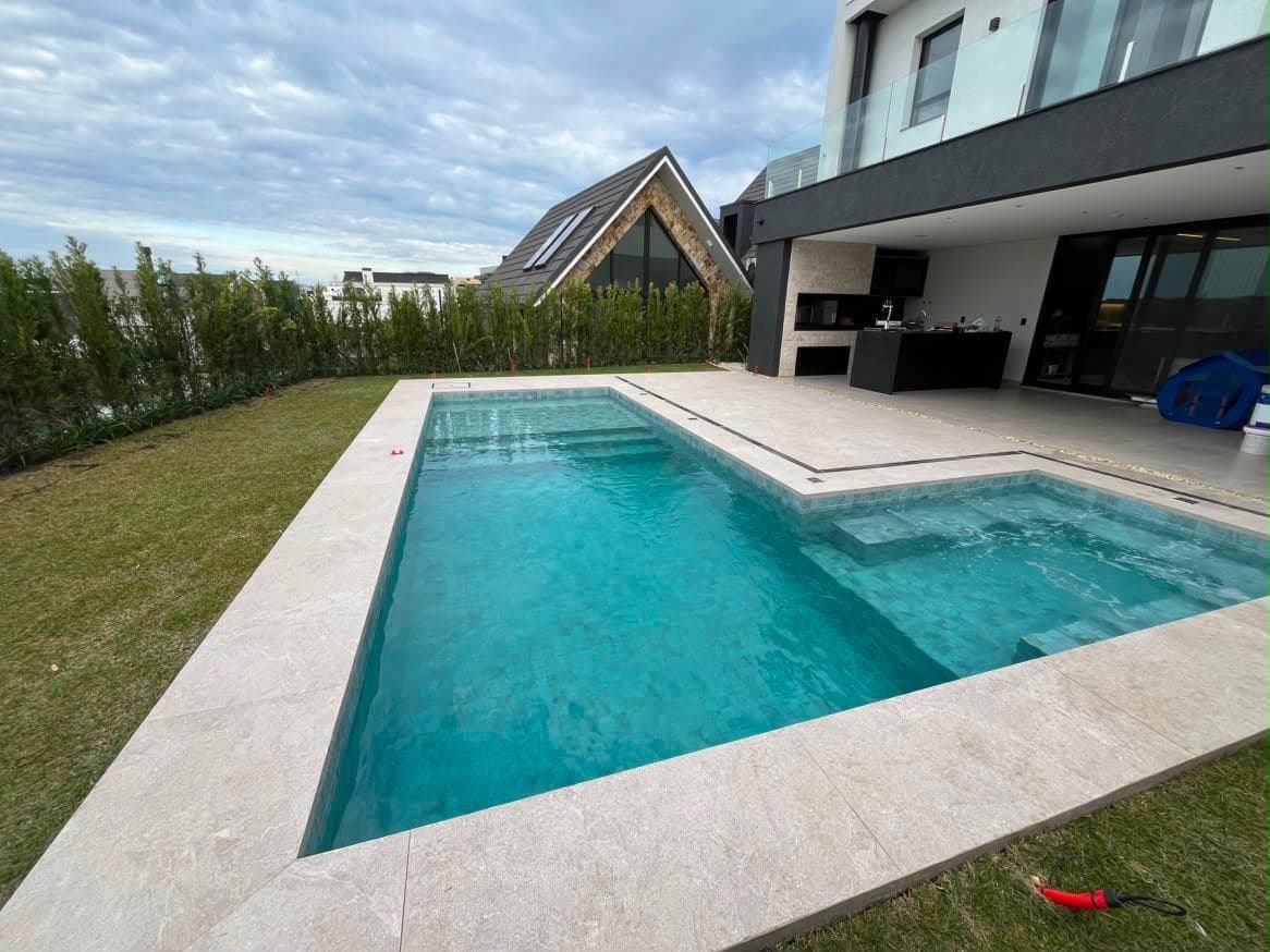 Piscina contemporânea integrada à área de lazer de uma residência